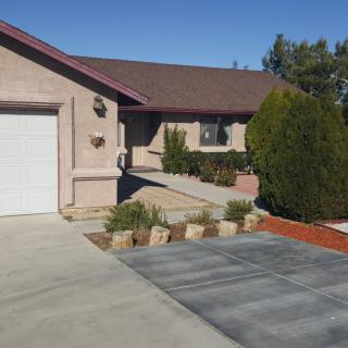 A suburban house with a driveway and well-maintained front yard on a sunny day.