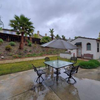 A rainy day on a backyard patio with outdoor furniture and an umbrella.