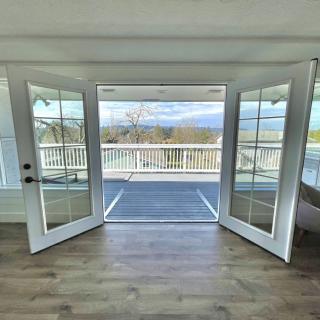 Open French doors leading to a deck with a scenic view.