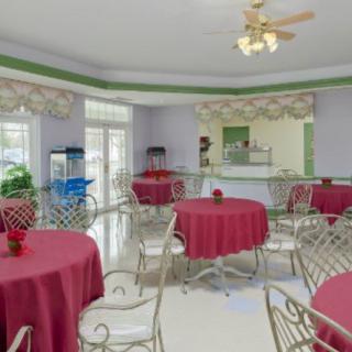 A cozy cafe interior with red tablecloths and metal chairs.