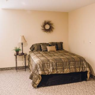 A cozy bedroom with a neatly made bed, decorative pillows, and complementary wall decor.