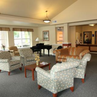 A cozy lounge area with comfortable seating and a piano.
