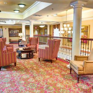 A spacious and elegantly designed lounge area with plush seating and ornate carpeting.