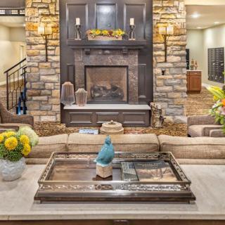 A cozy living room featuring a stone fireplace, stylish decor, and comfortable seating.