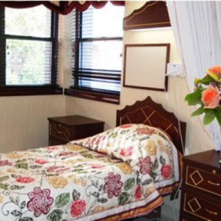 A cozy bedroom with floral bedding and wooden furniture.