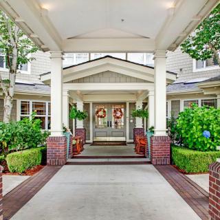 A welcoming entrance to a building with decorative columns and plants.