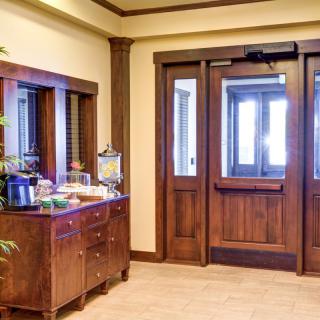A hotel lobby featuring wooden doors and a refreshment table.
