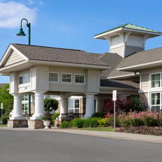 Modern residential building with landscaped surroundings and clear blue sky.