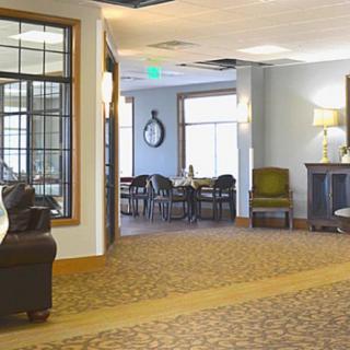 A cozy lobby area with seating and a dining table in a well-lit space.