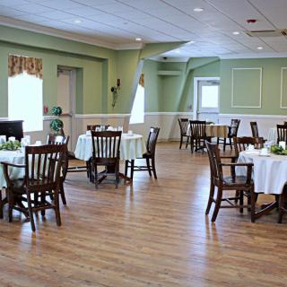 A spacious and elegantly decorated dining room with multiple tables and chairs arranged neatly.