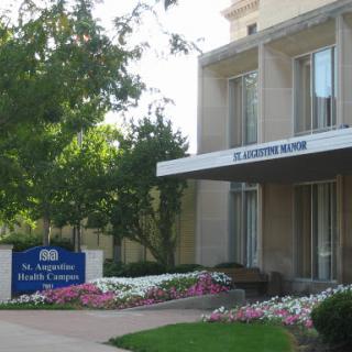 An exterior view of a building with landscaped gardens and clear signage.