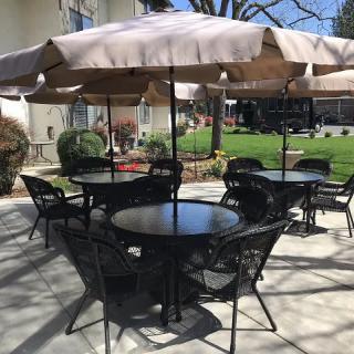 An outdoor patio area with tables, chairs, and umbrellas.