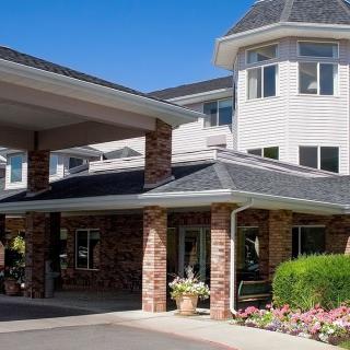 A residential building with a covered entrance and landscaping.