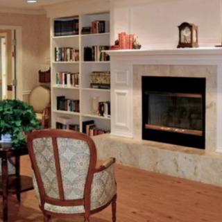 A cozy living room with a fireplace and built-in bookshelves.