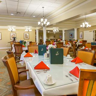 An elegantly set dining room with neatly arranged tables and chairs.