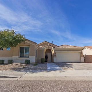 A single-story suburban house with a garage and driveway under a clear blue sky.
