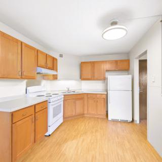 A bright and modern kitchen featuring wooden cabinets and essential appliances.