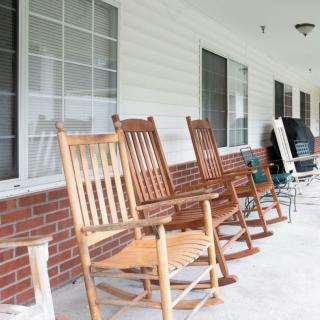 A row of wooden rocking chairs lined up on a porch.
