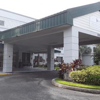A modern building entrance surrounded by well-maintained landscaping.