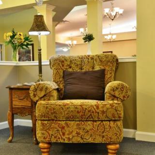 A cozy living room setting with a patterned armchair and side table.