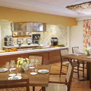 A cozy dining area with elegantly set tables and a view of the kitchen.
