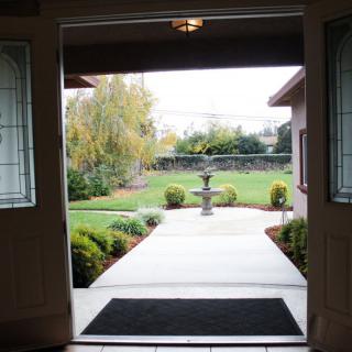 View from an open doorway leading to a landscaped garden with a central fountain.
