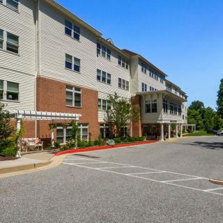 Exterior view of a multi-story residential building with parking area.