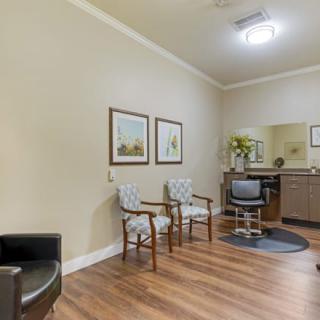 A cozy waiting area with chairs, artwork on the walls, and a small counter with a mirror.