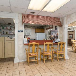 A cozy restaurant interior featuring a counter with chairs and tile flooring.