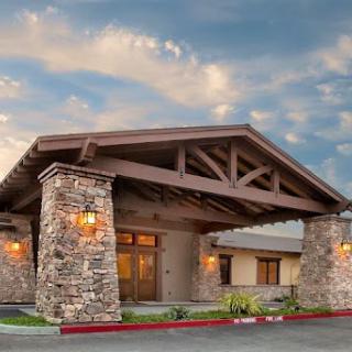 A welcoming entrance featuring a rustic design with stone pillars and wooden beams.