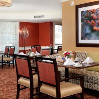 A well-appointed dining area with neatly arranged tables and chairs, featuring tasteful artwork on the wall.