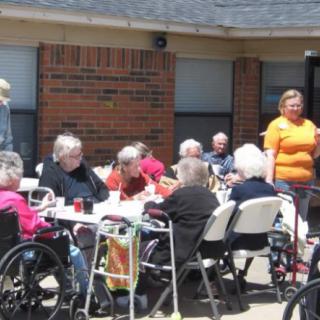 A group of seniors enjoying an outdoor gathering at a nursing home.