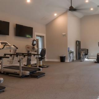 A spacious gym with various exercise machines and equipment.