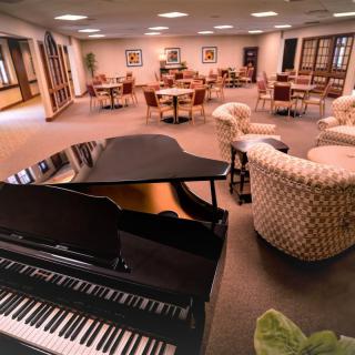 A cozy lounge area featuring a grand piano and comfortable seating.