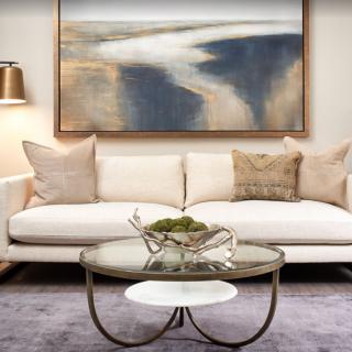 A modern living room featuring a comfortable sofa, abstract artwork, and a stylish coffee table.