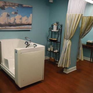 A serene spa room with a walk-in bathtub, elegant curtains, and calming decor.