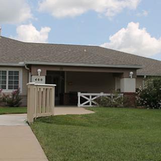 A charming suburban home with a welcoming porch and well-maintained lawn.