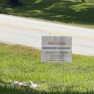 A roadside sign visible in a grassy area, likely conveying important information.