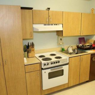 A kitchen with wooden cabinets, an electric stove, and countertop appliances.