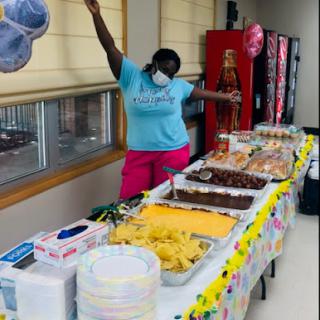 A vibrant celebration with a delicious spread of snacks and desserts, featuring a joyful participant enjoying the moment.