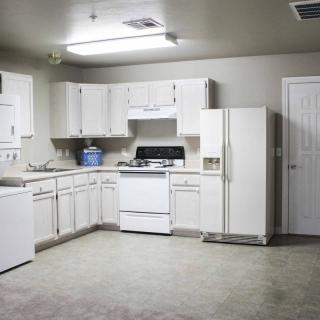 A modern kitchen with white cabinets and appliances.