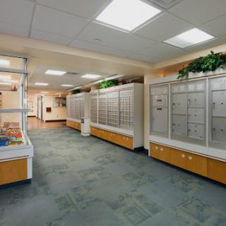 A well-lit interior hallway featuring mailboxes and modern furnishings.