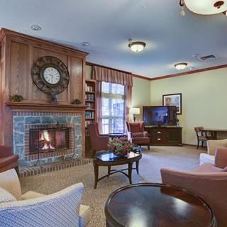 A cozy living room with a fireplace, comfortable seating, and a television set.
