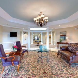 A luxurious lobby with elegant furniture and a central chandelier.