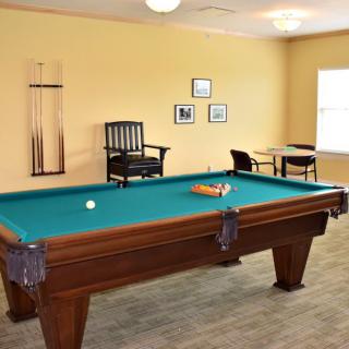 A cozy game room featuring a pool table and seating area.
