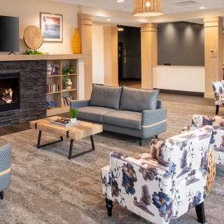 A modern lobby area featuring comfortable seating and a cozy fireplace.