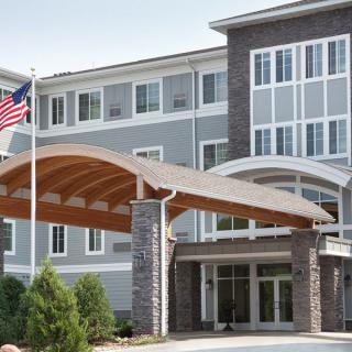 A modern building with a prominent entrance and an American flag.