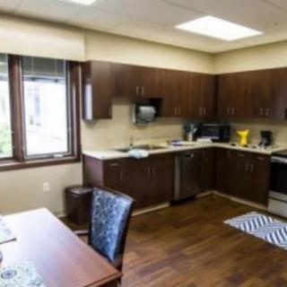 A modern kitchen interior with wooden cabinets and stainless steel appliances.