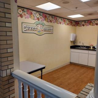 A small kitchenette with floral decor and basic amenities.