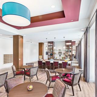 A modern lounge area with tables, chairs, and stylish lighting.